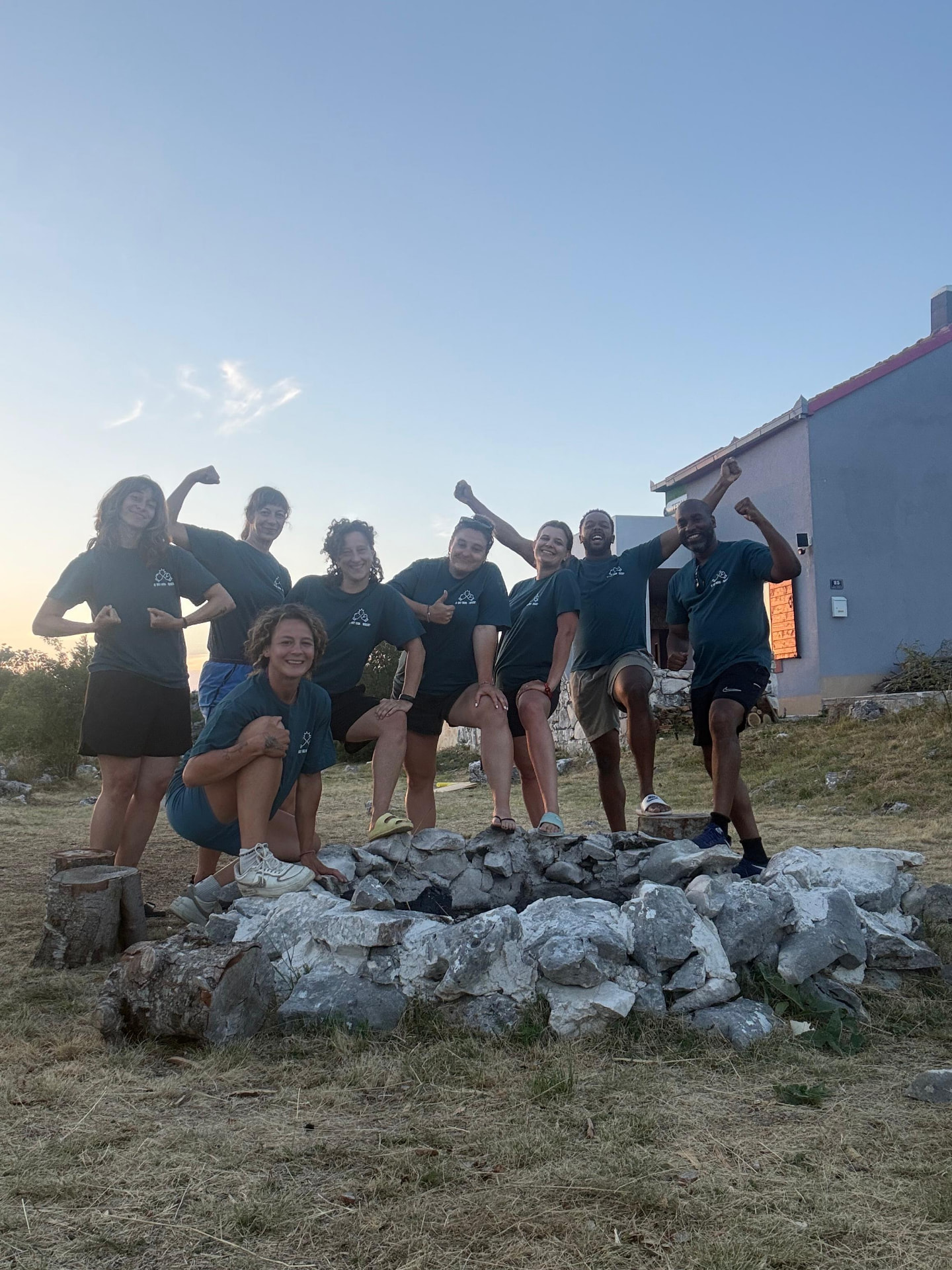The eight participants of the first Svilaja Tribe retreat, fists up at sunset by the fire pit